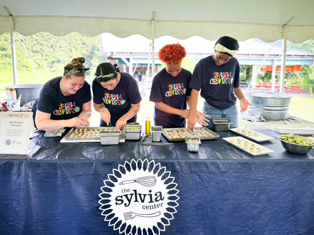 Annette Barlow helps teens from The Sylvia Center practice tasting
