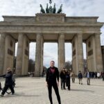 TCS NYC Marathon runner Morgan stands in front of a monument